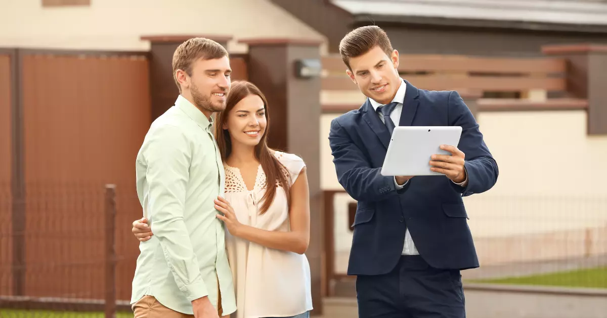 realtor with tablet showing to couple